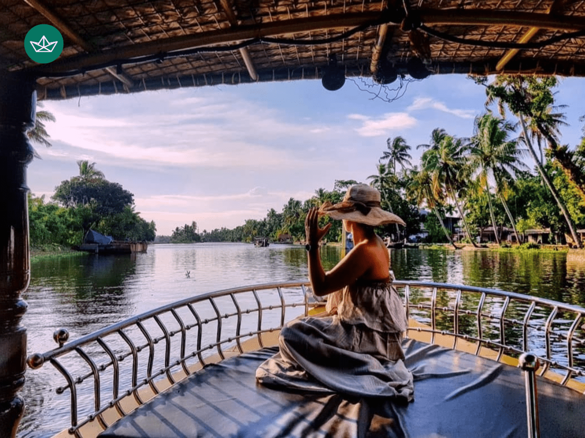 A tourist sitting in front deck of a shikara, enjoying the boat ride in Alleppey backwaters.